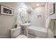 Bright bathroom featuring a pedestal sink, tub with tiled surround, and modern fixtures at 1644 W Roma Ave, Phoenix, AZ 85015