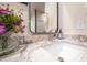 Close up of bathroom vanity with granite counter, fresh flowers and soap dispenser at 1644 W Roma Ave, Phoenix, AZ 85015