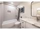 Bathroom features shower over tub, vanity with granite counters and storage, and black framed mirror at 1644 W Roma Ave, Phoenix, AZ 85015