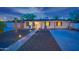 Well-maintained single-story home featuring xeriscaping, highlighted by blue chairs and a lit pathway at 1644 W Roma Ave, Phoenix, AZ 85015