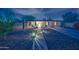 Charming single-story home with a well-lit walkway and chairs adding to the curb appeal at dusk at 1644 W Roma Ave, Phoenix, AZ 85015