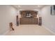 Entertainment room with stone accent wall, built-in cabinets, and adjacent game room at 1644 W Roma Ave, Phoenix, AZ 85015