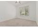 A neutral bedroom with a window view, ceiling fan, clean carpet, and ample natural light at 17 W Vernon Ave # 121, Phoenix, AZ 85003