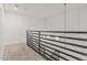 Upstairs hallway with metal railing and plush neutral carpet at 17 W Vernon Ave # 121, Phoenix, AZ 85003