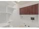 Well-lit laundry room with shelving and brown cabinets at 17 W Vernon Ave # 121, Phoenix, AZ 85003