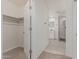 Bright walk-in closet with carpet, wooden rod, and an open door to a clean bathroom with modern fixtures at 17 W Vernon Ave # 121, Phoenix, AZ 85003