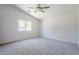 Spacious bedroom with vaulted ceiling, plush carpeting, a ceiling fan, and a large window at 17953 N Lettere Cir, Maricopa, AZ 85138