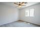 Bright bedroom features neutral carpet, a ceiling fan, and a window overlooking the outdoors at 17953 N Lettere Cir, Maricopa, AZ 85138