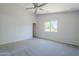 Bright bedroom features neutral carpet, a ceiling fan, and a window overlooking the outdoors at 17953 N Lettere Cir, Maricopa, AZ 85138