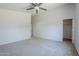 Spacious bedroom with walk-in closet, modern ceiling fan, and neutral carpet at 17953 N Lettere Cir, Maricopa, AZ 85138