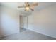 Bedroom features neutral carpet, a ceiling fan, and closet access at 17953 N Lettere Cir, Maricopa, AZ 85138