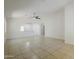 Bright living room with tile floors, ceiling fan, and open layout to kitchen and dining areas at 17953 N Lettere Cir, Maricopa, AZ 85138