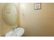 Half bathroom featuring a pedestal sink, an oval mirror, and neutral wall decor at 18586 N Lariat Rd, Maricopa, AZ 85138