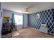 Spacious bedroom with geometric blue accent wall, ceiling fan, and natural light at 18586 N Lariat Rd, Maricopa, AZ 85138