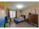 Cozy bedroom features playful, colorful walls, wood floors, natural light, and ample space at 18586 N Lariat Rd, Maricopa, AZ 85138