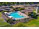 Aerial view of community pool with patio seating, lounge chairs, splashpad, and shade at 18586 N Lariat Rd, Maricopa, AZ 85138