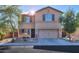 Two-story home featuring a neat front yard, neutral colors, and an attached two-car garage at 18586 N Lariat Rd, Maricopa, AZ 85138