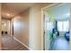 Inviting hallway with wood-style floors leads to bedroom with colorful wall art and ample natural light at 18586 N Lariat Rd, Maricopa, AZ 85138