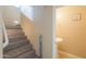 Hallway with wood stairs, leading to the half bath with pedestal sink at 18586 N Lariat Rd, Maricopa, AZ 85138