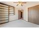 This bedroom features a ceiling fan, built-in shelves, a closet and soft neutral carpet at 1902 E 8Th St, Mesa, AZ 85203