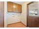 Laundry room with overhead cabinets and tile floor next to back door with window at 1902 E 8Th St, Mesa, AZ 85203