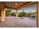 Covered brick patio with a fire pit and overlooking a serene green view of the golf course at 22208 N San Ramon Dr, Sun City West, AZ 85375