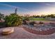 Backyard featuring a stone fire pit, a gorgeous rock water feature, desert landscaping and a community golf course at 22208 N San Ramon Dr, Sun City West, AZ 85375