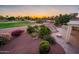 Expansive backyard with patio, built-in kitchen, lush landscaping, and a view of the community golf course at 22208 N San Ramon Dr, Sun City West, AZ 85375