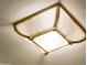 Low angle shot of glass encased ceiling light with metallic gold frame in bathroom at 22208 N San Ramon Dr, Sun City West, AZ 85375