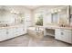 This bathroom is equipped with double vanity sinks, a tub, and herringbone tile flooring at 22208 N San Ramon Dr, Sun City West, AZ 85375