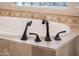 Elegant bathtub with modern fixtures and decorative tile surround at 22208 N San Ramon Dr, Sun City West, AZ 85375