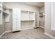 Spacious walk-in closet with custom shelving and herringbone-patterned wood floors for optimal storage at 22208 N San Ramon Dr, Sun City West, AZ 85375