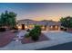 Charming desert home with a tiled roof, three-car garage, and landscaped yard at dusk at 22208 N San Ramon Dr, Sun City West, AZ 85375