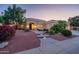 Landscaped desert home with a paver walkway and warm exterior lighting at dusk at 22208 N San Ramon Dr, Sun City West, AZ 85375