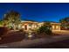 Inviting single-story home with manicured landscaping and illuminated walkway leading to a red front door at 22208 N San Ramon Dr, Sun City West, AZ 85375