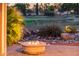 Patio view with a cozy fire pit overlooking a lush golf course and desert landscaping at 22208 N San Ramon Dr, Sun City West, AZ 85375