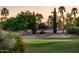 Scenic golf course with lush green fairways, sand traps, and mature trees at sunset at 22208 N San Ramon Dr, Sun City West, AZ 85375