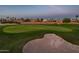 Scenic view of the golf course features manicured green, sand trap and community homes in the background at 22208 N San Ramon Dr, Sun City West, AZ 85375
