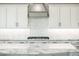 Bright kitchen featuring white cabinets, stylish backsplash, and stone countertops at 22208 N San Ramon Dr, Sun City West, AZ 85375
