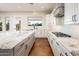Bright kitchen with white cabinets, granite countertops, tile floor, and stainless steel appliances at 22208 N San Ramon Dr, Sun City West, AZ 85375