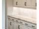 Kitchen with white cabinets, marble countertops, and black hardware at 22208 N San Ramon Dr, Sun City West, AZ 85375