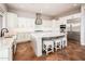 Bright kitchen with white cabinetry, an island with seating, and modern appliances at 22208 N San Ramon Dr, Sun City West, AZ 85375