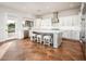 Bright kitchen features white cabinetry, marble countertops, and an island with seating at 22208 N San Ramon Dr, Sun City West, AZ 85375