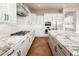 Modern white kitchen with marble countertops, stainless steel appliances, and gas cooktop at 22208 N San Ramon Dr, Sun City West, AZ 85375