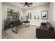 Home office with a desk, leather couch, shelving, and arched windows overlooks a verdant outdoor view at 22208 N San Ramon Dr, Sun City West, AZ 85375