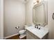 Elegant powder room featuring marble countertop, decorative mirror, and brushed bronze faucet and fixtures at 22208 N San Ramon Dr, Sun City West, AZ 85375