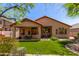 Well-manicured backyard with a covered patio, lush lawn, and mature landscaping at 22232 N 48Th St, Phoenix, AZ 85054