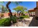Spacious backyard featuring a covered patio, seating area, lush landscaping, and gravel areas at 22232 N 48Th St, Phoenix, AZ 85054