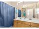 Well-lit bathroom features double vanity with wood cabinets and a large mirror, complete with shower and tub at 22232 N 48Th St, Phoenix, AZ 85054