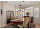 Elegant dining room features a wood table, upholstered chairs, a chandelier, and plantation shutters creating a warm atmosphere at 22232 N 48Th St, Phoenix, AZ 85054